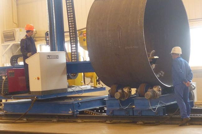 Stand for automatic longitudinal welding of the shell seam